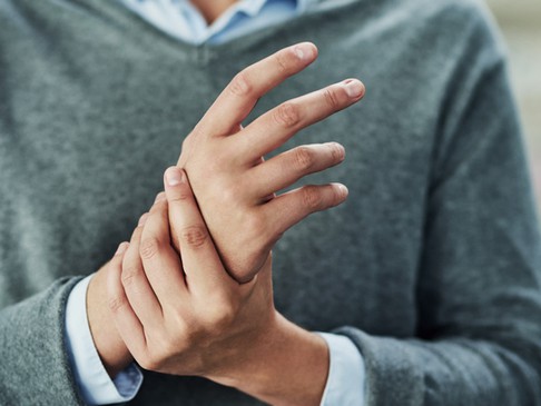 A man holds his right hand with his left