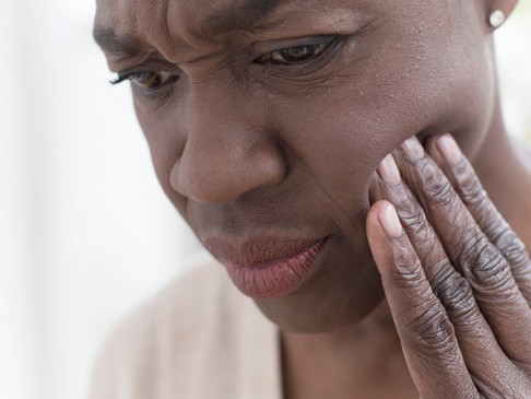 A man holding his jaw in an obvious sign of pain