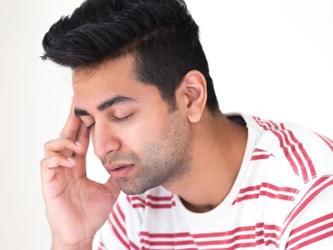 A man showing signs of pain in the head and jaw