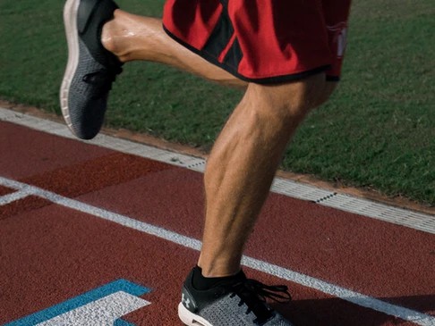 legs of a runner on a running track