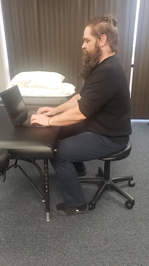 David demonstrates a better sitting position for working on a computer