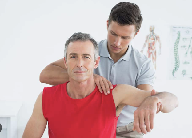 Shoulder pain after a car accident - Bodywork therapist providing manual therapy on man experiencing shoulder pain